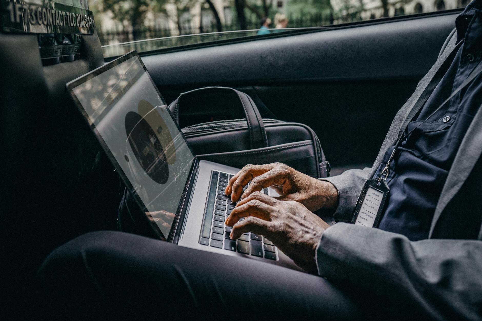 Professional executive working on laptop in luxury car, reach Volantis anytime